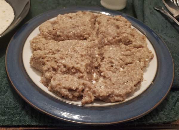 Vegan kibbey nayye in a round mound on a round plate, with a cross indented in its surface.